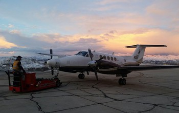The King Air moves into a hangar; snow clouds are in the background.